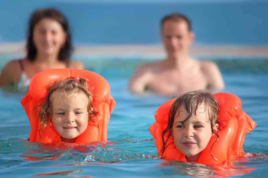 two young using lifejackets while swimming